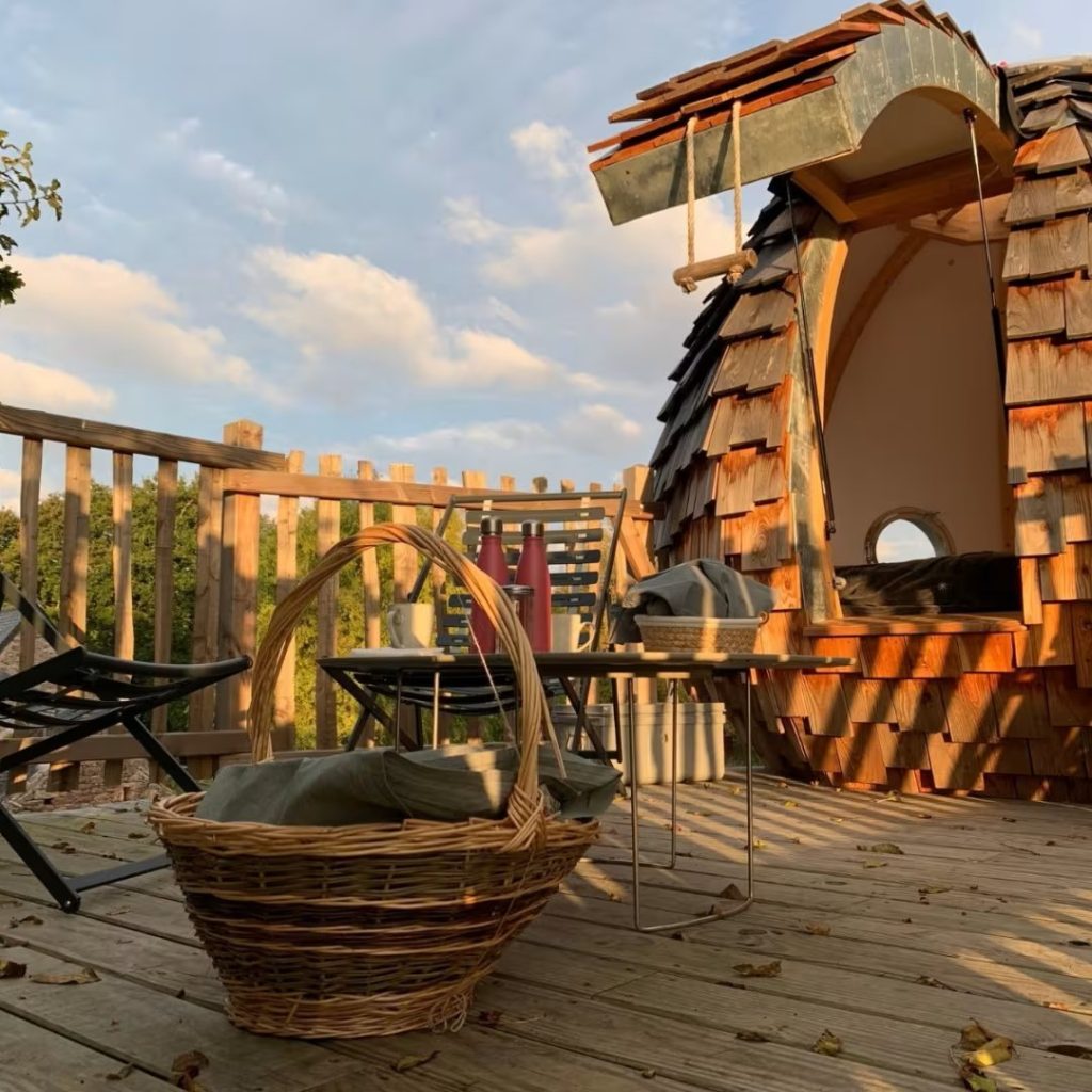 hebergement insolite en hauteur type nid d'oiseau avec panier du petit dejeuner au premier plan